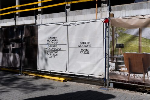 Outdoor banners showcasing square mockup templates with resolution details for designers on a construction site fence, urban setting.